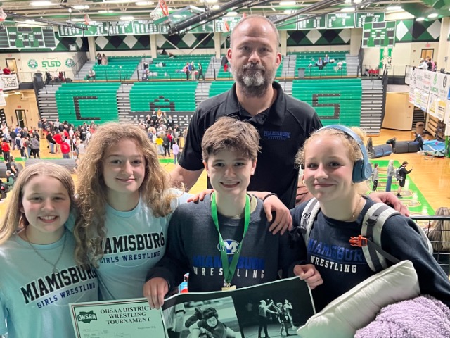 Lila Krull poses with teammates Elin Flanigan, Livi Krull, Livi Elsass, and Coach Dustin Krull 