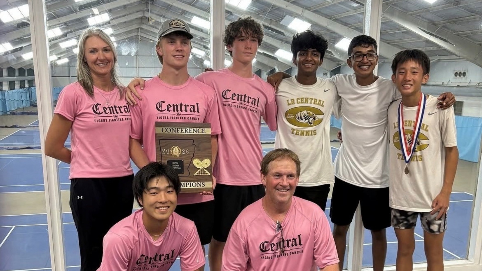 Central Boys Tennis team athletes and coach holding the 6A Central Conference Championship trophy while taking a picture.