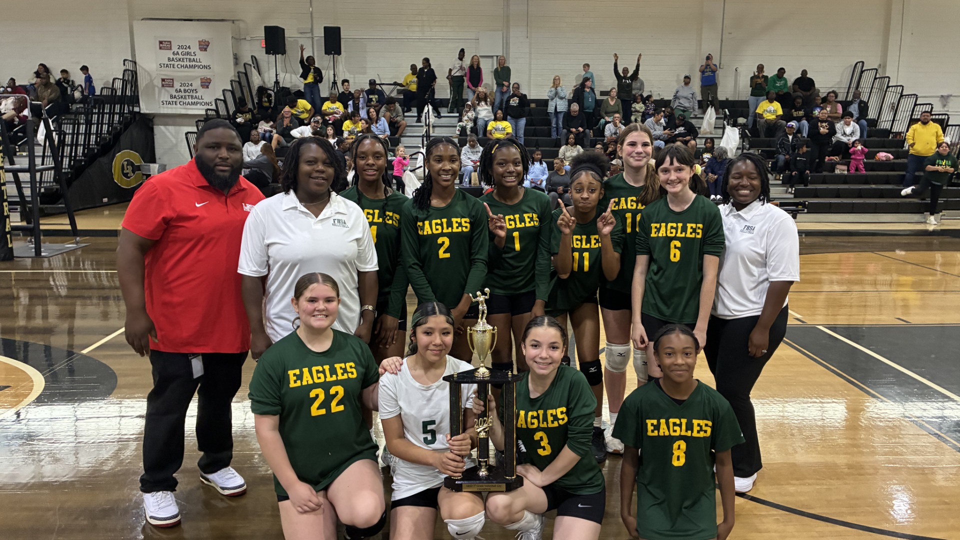 Forest Heights 7th graders along with coaches posing with the championship trophy.