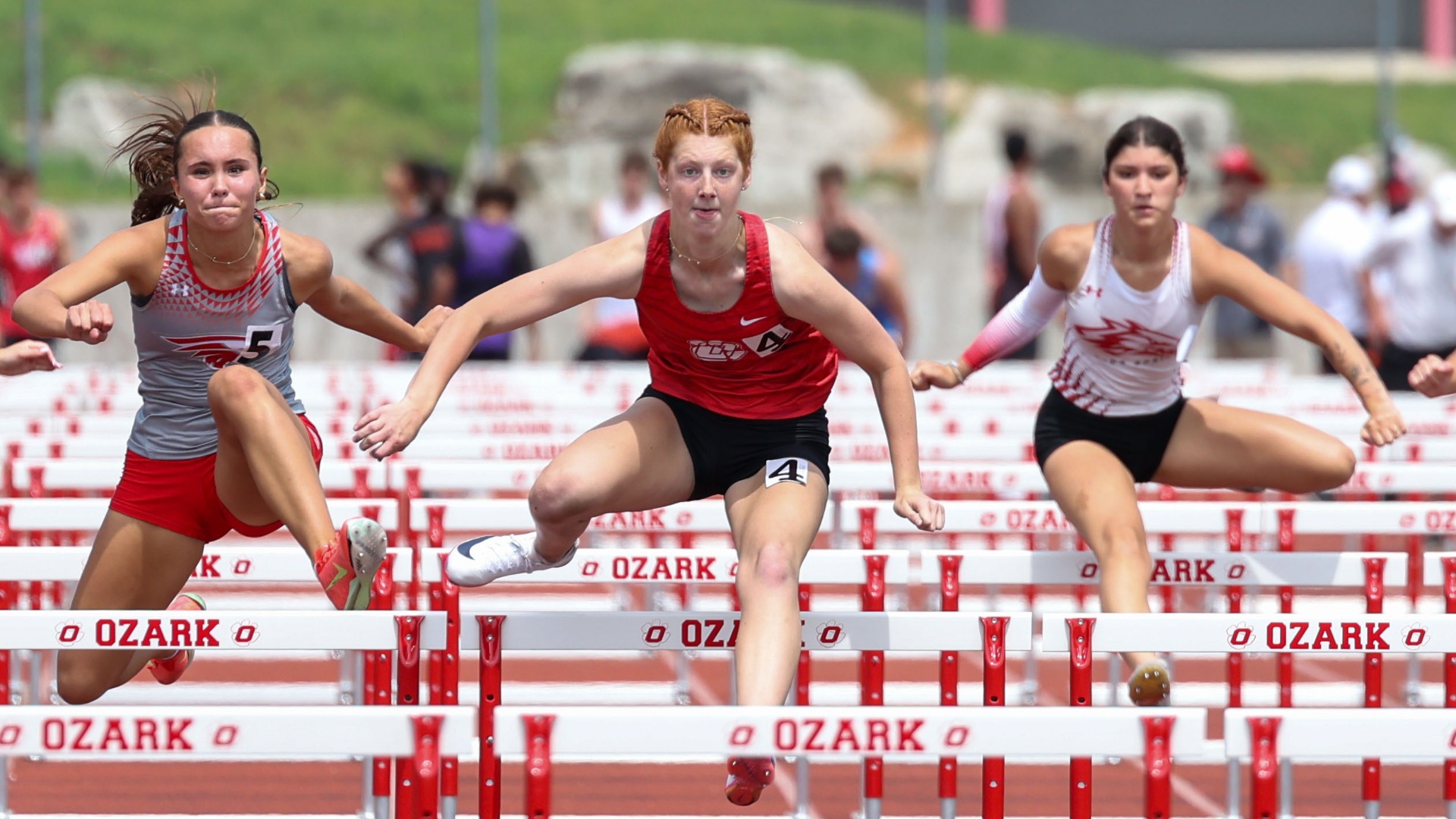 Slide 2 - Senior Bria Wright hurdles her way to the finish line at the Christian County Relays