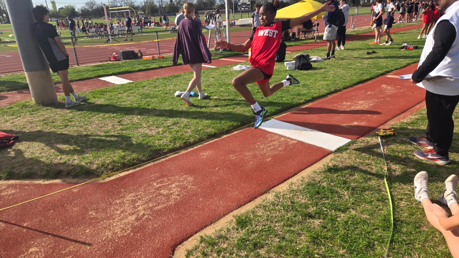 Slide 2 - Kena Kimathi soaring in the long jump at the Heritage Relays!